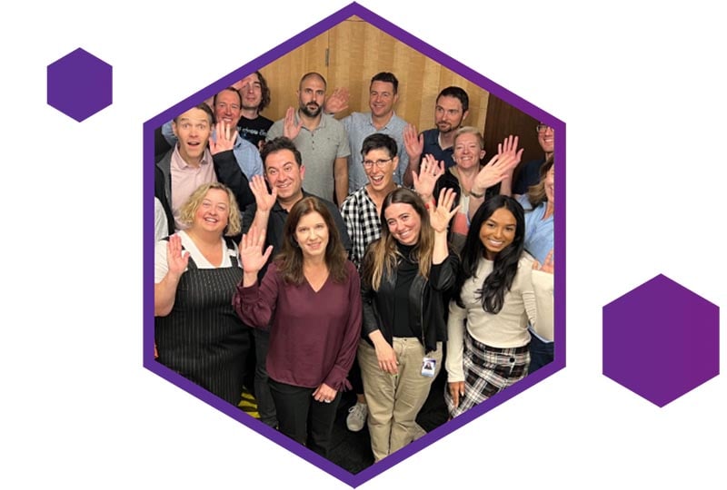 An image of a group of people smiling and waving